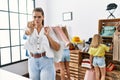 Young beautiful woman with two daughters holding shopping bags at retail shop pointing with finger to the camera and to you, Royalty Free Stock Photo