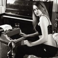 Young beautiful woman typing on a retro typewriter. female writer in bra and men`s trousers. black and white Royalty Free Stock Photo