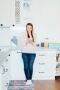 Young beautiful woman using cell phone in the kitchen Royalty Free Stock Photo