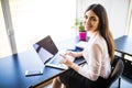 Young beautiful woman using her laptop while sitting in chair at her working place Royalty Free Stock Photo