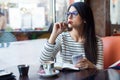 Young beautiful woman using her mobile phone in coffee. Royalty Free Stock Photo