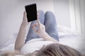 Young beautiful woman using mobile phone on her bed Royalty Free Stock Photo