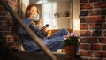 Young Beautiful Woman Using Smartphone and Enjoying her Morning Coffee While Sitting on her Bedroom Royalty Free Stock Photo