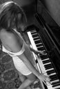 Young beautiful woman in a vest playing the piano Royalty Free Stock Photo