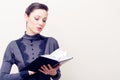 Young beautiful woman in vintage dress reading bible Royalty Free Stock Photo