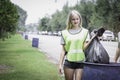 Young beautiful woman volunteer collecting trash garbage, holding and dumping garbage bag, clean up area of dirty, environmental Royalty Free Stock Photo