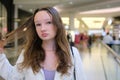 Young beautiful woman walking along the street doing shopping, stylish girl looking at clothes shop window. Royalty Free Stock Photo