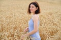 Young beautiful woman walking in golden wheat field at sunset. Freedom concept Royalty Free Stock Photo