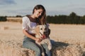 Young beautiful woman walking with her golden retriever dog on a yellow field at sunset. Nature and lifestyle outdoors Royalty Free Stock Photo