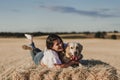 Young beautiful woman walking with her golden retriever dog on a yellow field at sunset. Nature and lifestyle outdoors Royalty Free Stock Photo