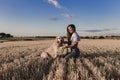 Young beautiful woman walking with her golden retriever dog on a yellow field at sunset. Nature and lifestyle outdoors Royalty Free Stock Photo