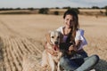 Young beautiful woman walking with her golden retriever dog on a yellow field at sunset. Nature and lifestyle outdoors Royalty Free Stock Photo