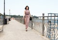 Young beautiful woman walking on the sidewalk in summer Royalty Free Stock Photo