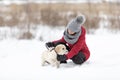 Young beautiful woman walking in snow with her dog on snowy winter day Royalty Free Stock Photo