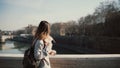 Young beautiful woman walking in the sunny morning on the bridge. Attractive female drinking coffee and have a stroll. Royalty Free Stock Photo