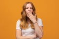 Young beautiful woman with wavy redhead bored yawning tired covering mouth with hand. Restless and sleepiness