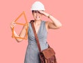 Young beautiful woman wearing architect hardhat holding build project stressed and frustrated with hand on head, surprised and Royalty Free Stock Photo