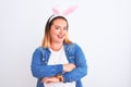 Young beautiful woman wearing banny ears standing over isolated white background happy face smiling with crossed arms looking at Royalty Free Stock Photo