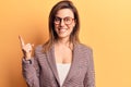 Young beautiful woman wearing business clothes and glasses smiling happy pointing with hand and finger to the side Royalty Free Stock Photo