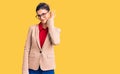 Young beautiful woman wearing business shirt and glasses smiling with hand over ear listening an hearing to rumor or gossip Royalty Free Stock Photo