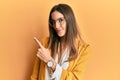 Young beautiful woman wearing business style and glasses pointing with hand finger to the side showing advertisement, serious and Royalty Free Stock Photo