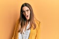 Young beautiful woman wearing business style and glasses in shock face, looking skeptical and sarcastic, surprised with open mouth Royalty Free Stock Photo