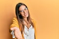 Young beautiful woman wearing business style and glasses smiling cheerful offering palm hand giving assistance and acceptance Royalty Free Stock Photo