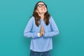 Young beautiful woman wearing casual clothes and glasses begging and praying with hands together with hope expression on face very Royalty Free Stock Photo