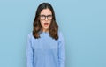 Young beautiful woman wearing casual clothes and glasses in shock face, looking skeptical and sarcastic, surprised with open mouth Royalty Free Stock Photo