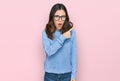 Young beautiful woman wearing casual clothes and glasses surprised pointing with finger to the side, open mouth amazed expression Royalty Free Stock Photo