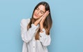 Young beautiful woman wearing casual clothes sleeping tired dreaming and posing with hands together while smiling with closed eyes Royalty Free Stock Photo