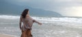 Woman wearing casual clothing enjoying sea storm and water waves of the sea on the beach Royalty Free Stock Photo