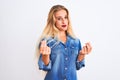 Young beautiful woman wearing casual denim shirt standing over isolated white background doing money gesture with hands, asking Royalty Free Stock Photo