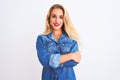 Young beautiful woman wearing casual denim shirt standing over isolated white background happy face smiling with crossed arms Royalty Free Stock Photo