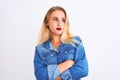 Young beautiful woman wearing casual denim shirt standing over isolated white background looking to the side with arms crossed Royalty Free Stock Photo