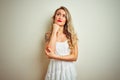 Young beautiful woman wearing casual dress standing over white isolated background with hand on chin thinking about question, Royalty Free Stock Photo