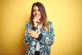 Young beautiful woman wearing casual jacket over yellow isolated background laughing nervous and excited with hands on chin Royalty Free Stock Photo