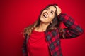 Young beautiful woman wearing casual jacket standing over red isolated background Pointing to both sides with fingers, different