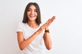 Young beautiful woman wearing casual t-shirt standing over isolated white background clapping and applauding happy and joyful, Royalty Free Stock Photo