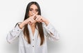 Young beautiful woman wearing casual white shirt rejection expression crossing fingers doing negative sign Royalty Free Stock Photo