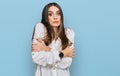 Young beautiful woman wearing casual white shirt shaking and freezing for winter cold with sad and shock expression on face Royalty Free Stock Photo