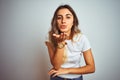 Young beautiful woman wearing casual white t-shirt over  background looking at the camera blowing a kiss with hand on air Royalty Free Stock Photo