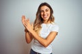 Young beautiful woman wearing casual white t-shirt over isolated background clapping and applauding happy and joyful, smiling Royalty Free Stock Photo