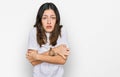 Young beautiful woman wearing casual white t shirt shaking and freezing for winter cold with sad and shock expression on face Royalty Free Stock Photo