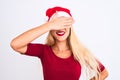 Young beautiful woman wearing Christmas Santa hat over isolated white background smiling and laughing with hand on face covering Royalty Free Stock Photo
