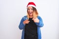 Young beautiful woman wearing Christmas Santa hat standing over isolated white background pointing fingers to camera with happy Royalty Free Stock Photo