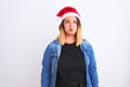 Young beautiful woman wearing Christmas Santa hat standing over isolated white background puffing cheeks with funny face Royalty Free Stock Photo