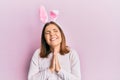 Young beautiful woman wearing cute easter bunny ears begging and praying with hands together with hope expression on face very