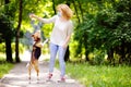 Young beautiful woman wearing disposable medical face mask playing with Beagle dog in the park during coronavirus outbreak.