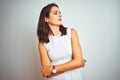 Young beautiful woman wearing dress standing over white isolated background looking to the side with arms crossed convinced and Royalty Free Stock Photo